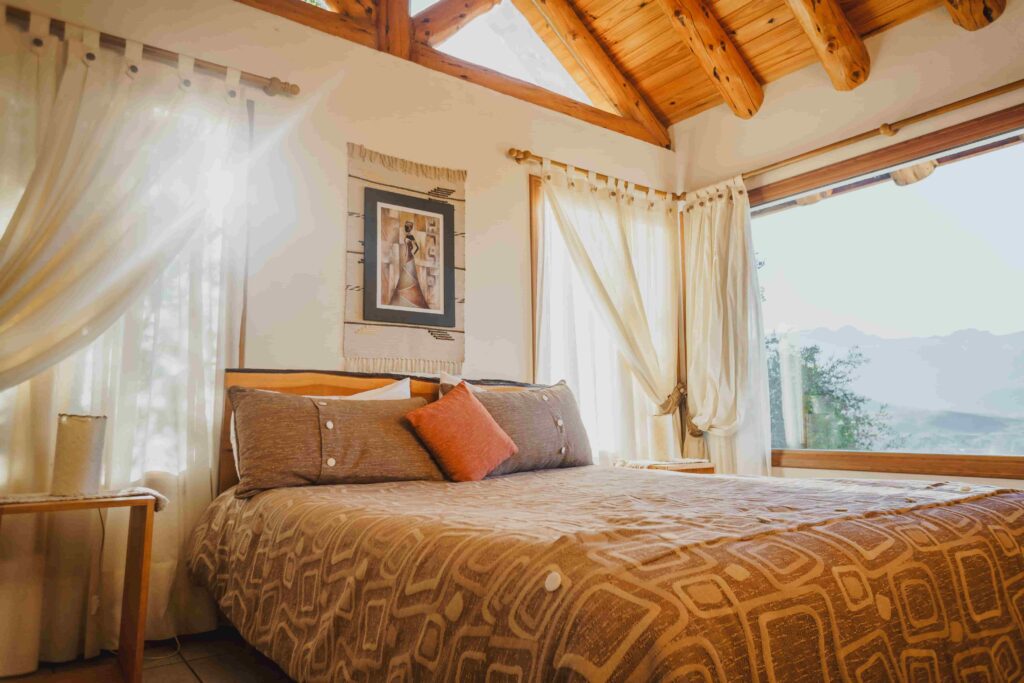 Cabaña con cama matrimonial y vista a la montaña desde el ventanal