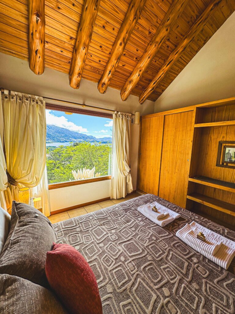 Ropa blanca y amenities sobre la cama en cabaña de montaña